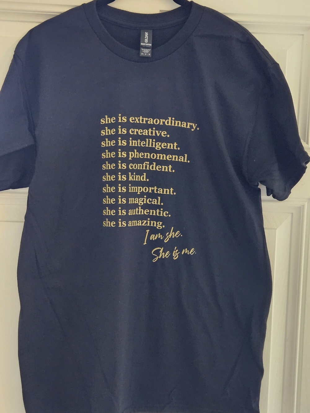 Black Graphic Tee with Gold Affirmation Text "She Is Me"